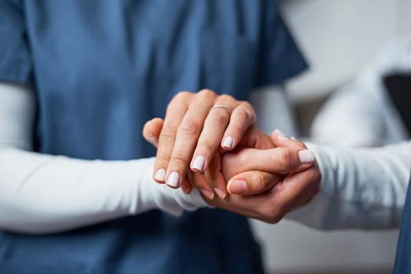 A close-up of a nurse holding a patient's hand
AI-generated content may be incorrect.