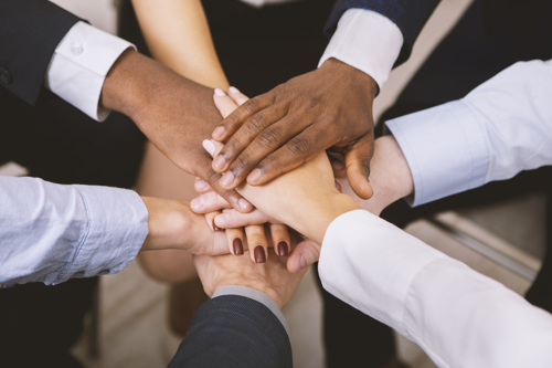 Multiple team members put hands in